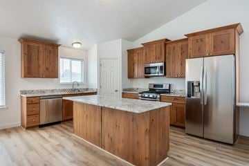 Eagle Mountain apartment for rent - A kitchen with wooden cabinets and stainless steel appliances.