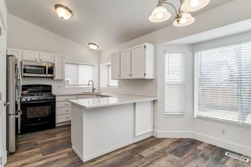 West Jordan apartment for rent - A kitchen with white cabinets and a black stove top oven.