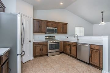 West Jordan apartment for rent - A kitchen with a refrigerator, oven, microwave, and sink.
