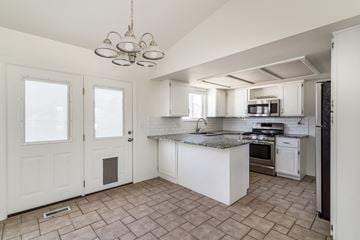 Roy apartment for rent - A kitchen with white cabinets and a tile floor.