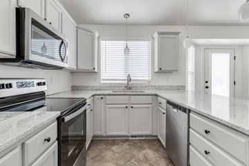 Layton apartment for rent - A kitchen with white cabinets and a marble countertop.