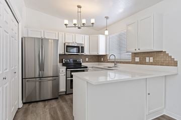 Syracuse apartment for rent - A kitchen with white cabinets and a stainless steel refrigerator.