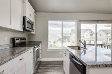Saratoga Springs apartment for rent - A kitchen with white cabinets and a granite countertop.