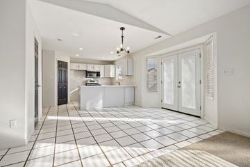 Provo apartment for rent - A kitchen with white cabinets and a black fridge is seen from the hallway.