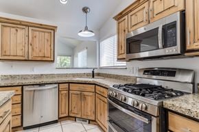 Woods Cross apartment for rent - A kitchen with wooden cabinets and granite countertops.