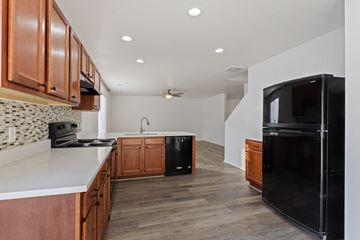 Spanish Fork apartment for rent - A kitchen with wooden cabinets and black appliances.