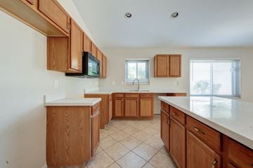Queen Creek apartment for rent - A kitchen with wooden cabinets and a white countertop.
