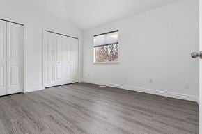 West Jordan apartment for rent - A room with white walls and a window showing trees outside.