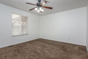 West Jordan apartment for rent - A room with a ceiling fan and carpeted floor.