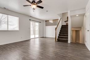 Spanish Fork apartment for rent - A spacious room with a ceiling fan and wooden flooring.