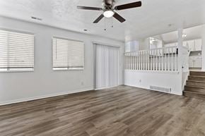 Layton apartment for rent - A spacious room with a ceiling fan and wooden flooring.