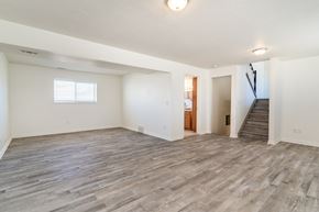 Roy apartment for rent - the living room and entryway of an empty house with wood flooring