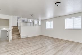 Layton apartment for rent - A spacious room with wooden floors and a staircase leading to another level.