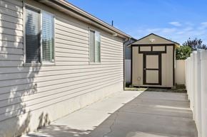 North Salt Lake apartment for rent - A small building with a brown door is situated next to a house.