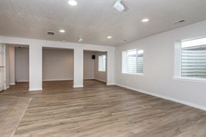 Herriman apartment for rent - an empty living room with a wooden floor and white walls