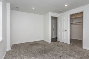West Jordan apartment for rent - A room with a carpeted floor and a doorway leading to another room.