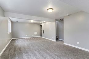 Layton apartment for rent - A spacious room with grey carpeting and white walls.