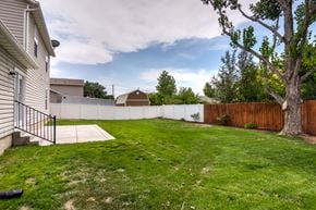 Lehi apartment for rent - the backyard of a house with a fence and a grassy yard