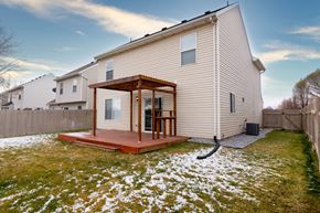 Saratoga Springs apartment for rent - the back of a house with a wooden deck in the snow