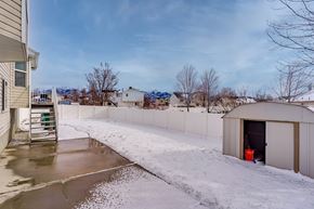 Layton apartment for rent - A snowy landscape with a building and a shed.