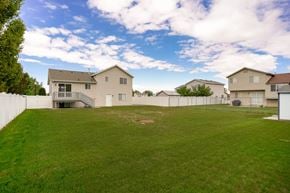 Clinton apartment for rent - A backyard with a large grassy area and a few houses in the background.