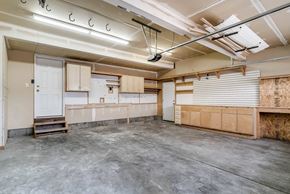 West Jordan apartment for rent - A large empty room with a door on the left and a wall covered in insulation on the right.