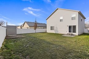 Spanish Fork apartment for rent - a backyard with a white house and a white fence
