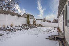 Herriman apartment for rent - a backyard covered in snow with a fence and a house