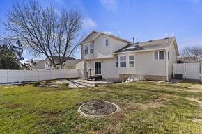 Layton apartment for rent - A house with a white fence and a tree in the front yard.