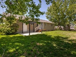 Syracuse apartment for rent - A house with a green lawn and a tree in front.
