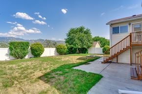 Woods Cross apartment for rent - A house with a brown deck and a green lawn.