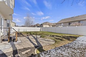 Layton apartment for rent - A backyard with a white fence and a small patio area.