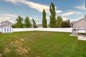 Clinton apartment for rent - A backyard with a white fence and a tree.