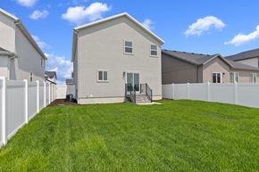 Eagle Mountain apartment for rent - A house with a white fence and a green lawn.