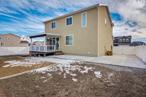 Stansbury Park apartment for rent - A beige house with a white fence and a small porch.