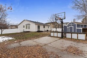 Layton apartment for rent - A basketball hoop stands in the middle of a driveway with a house in the background.