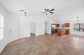Vail apartment for rent - an empty living room with a ceiling fan and a kitchen