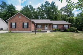 Milford apartment for rent - A red brick house with a white garage door and a black pole in front of it.