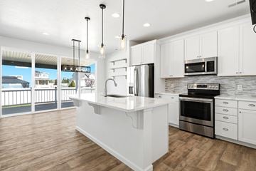 Stansbury Park apartment for rent - A modern kitchen with white cabinets and a wooden floor.