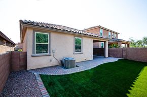 Sahuarita apartment for rent - A house with a brown roof and tan walls with a green lawn in front.
