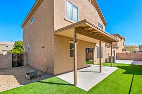 Peoria apartment for rent - the backyard of a brick house with a porch and grass