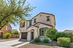 Queen Creek apartment for rent - A house with a brown garage door and a tree in front.