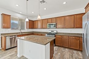 Queen Creek apartment for rent - A kitchen with brown cabinets and a granite countertop.