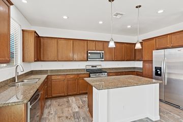 Queen Creek apartment for rent - A kitchen with wooden cabinets and a granite countertop.
