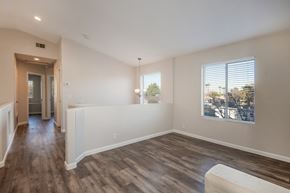 Gilbert apartment for rent - an empty living room with a large window and wood flooring