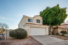 Gilbert apartment for rent - a white house with a white garage door and a tree