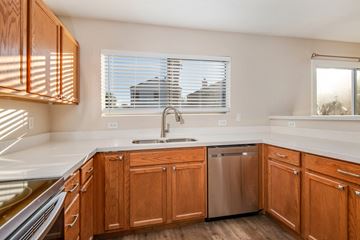 Gilbert apartment for rent - A kitchen with wooden cabinets and a stainless steel dishwasher.