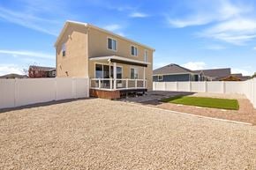 Stansbury Park apartment for rent - A house with a white fence and a gravel driveway.