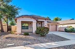Gilbert apartment for rent - A house with a gravel driveway and a small bush in front.