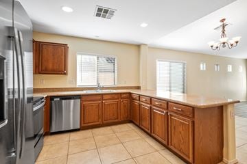Gilbert apartment for rent - A kitchen with wooden cabinets and a stainless steel refrigerator.